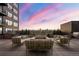 Outdoor patio with lounge seating, a fire pit, and a colorful sunset at 1674 Fillmore St # Al3, Denver, CO 80206