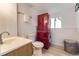 Compact bathroom featuring a bright red stacked washer and dryer unit and modern fixtures at 9958 Milwaukee St, Thornton, CO 80229