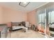Cozy pink Bedroom featuring a gray crib, a rocking chair, and natural light at 9958 Milwaukee St, Thornton, CO 80229
