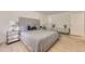 Bright bedroom featuring a gray tufted headboard, light wood floors and modern bedside tables at 9958 Milwaukee St, Thornton, CO 80229