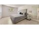Bright bedroom with a large bed, tufted headboard, light wood floors, and natural light from the window at 9958 Milwaukee St, Thornton, CO 80229