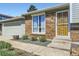 Inviting home entrance showcasing a brick facade, well-maintained landscaping, and secure door with decorative bars at 9958 Milwaukee St, Thornton, CO 80229