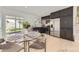 Bright kitchen featuring stainless steel appliances, dark cabinets, modern countertops, and dining area with a glass table at 9958 Milwaukee St, Thornton, CO 80229