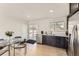 Bright kitchen featuring stainless steel appliances, dark cabinets, modern countertops, and dining area with a glass table at 9958 Milwaukee St, Thornton, CO 80229