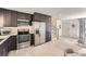 Modern kitchen with stainless steel appliances, dark cabinetry, bright countertops, and open access to the living area at 9958 Milwaukee St, Thornton, CO 80229