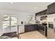 Modern kitchen with stainless steel appliances, dark cabinetry, bright countertops, and a sliding door to the backyard at 9958 Milwaukee St, Thornton, CO 80229