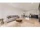 Open-concept living area with a gray sofa, glass-top coffee table, dining area, and stainless steel appliances at 9958 Milwaukee St, Thornton, CO 80229