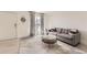 Cozy living room with a gray sofa, decorative mirror, a glass-top coffee table, and natural light at 9958 Milwaukee St, Thornton, CO 80229