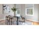 Elegant dining room with a glass-topped table and stylish chairs, illuminated by natural light from multiple windows at 40 Madison St # 103, Denver, CO 80206