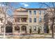 Tan stucco exterior showcasing balconies, covered porches and professional winter landscaping at 40 Madison St # 103, Denver, CO 80206