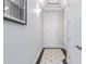 Hallway showing gray walls, white trim, tiled floors, and a white door at 40 Madison St # 103, Denver, CO 80206