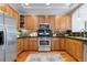 Well-equipped kitchen featuring ample wooden cabinetry, stainless appliances and stone counters at 40 Madison St # 103, Denver, CO 80206