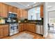 Charming kitchen with stainless steel appliances, wood cabinets, and stone backsplash at 40 Madison St # 103, Denver, CO 80206