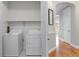 Bright laundry room with white washer, dryer and convenient upper shelving at 40 Madison St # 103, Denver, CO 80206