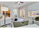 Bright living room with modern furniture, a ceiling fan, and access to an outdoor space through glass doors at 40 Madison St # 103, Denver, CO 80206