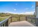 Relaxing deck with wood flooring and railings overlooking green landscape and neighborhood in the distance at 476 Hyde Park Cir, Castle Pines, CO 80108