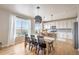Sunlit dining area with a modern light fixture, hardwood floors, and expansive windows with scenic views at 476 Hyde Park Cir, Castle Pines, CO 80108