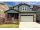 Charming two-story home featuring a covered porch, two-car garage, and manicured front lawn at 476 Hyde Park Cir, Castle Pines, CO 80108