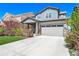 Exterior elevation features a two-car garage, covered porch, stone accents, and manicured landscaping at 476 Hyde Park Cir, Castle Pines, CO 80108