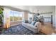 Bright living room featuring large windows, hardwood floors, and an open layout connecting to the kitchen at 476 Hyde Park Cir, Castle Pines, CO 80108