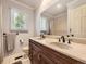 Well-lit bathroom featuring double sinks, a large mirror, and neutral-toned walls at 7782 S Louthan St, Littleton, CO 80120