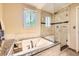 Luxurious bathroom featuring a soaking tub, a glass shower, and bright windows for a spa-like experience at 7782 S Louthan St, Littleton, CO 80120