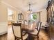 Formal dining room featuring a wood table, classic chandelier, and natural light from a bright window at 7782 S Louthan St, Littleton, CO 80120