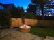 Backyard patio featuring a stone fire pit with a roaring fire, surrounded by a cozy seating area at 7782 S Louthan St, Littleton, CO 80120