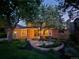 Charming brick home featuring mature trees and a welcoming front porch, creating an inviting curb appeal at 7782 S Louthan St, Littleton, CO 80120