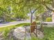 Relaxing front yard featuring Adirondack chairs, a small table, and shade trees, creating a welcoming curb appeal at 7782 S Louthan St, Littleton, CO 80120