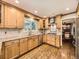 Bright kitchen with wooden cabinets, granite counters, stainless steel appliances and a view of the backyard at 7782 S Louthan St, Littleton, CO 80120