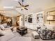 Bright living room featuring vaulted ceilings, a ceiling fan, built-in shelving, and comfortable seating at 7782 S Louthan St, Littleton, CO 80120