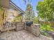 Outdoor kitchen featuring a built-in grill and counter, set on a stone patio with a covered dining area at 7782 S Louthan St, Littleton, CO 80120