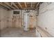 Unfinished basement with a water heater, concrete floor, brick foundation walls, and bench at 2245 Julian St, Denver, CO 80211