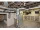 Unfinished basement with exposed pipes, wooden beams, a furnace, and open shelves at 2245 Julian St, Denver, CO 80211