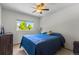 Neutral bedroom features a ceiling fan and a window with a view of trees at 2430 E 109Th Dr, Northglenn, CO 80233