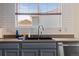 Close up of the kitchen sink, faucet, and subway tile backsplash with a window view at 2430 E 109Th Dr, Northglenn, CO 80233