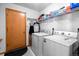 The laundry room has a washer, dryer, shelving and a door with a coat rack at 2430 E 109Th Dr, Northglenn, CO 80233