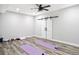 Large home gym with ceiling fan, a sliding barn door, and hardwood flooring at 14850 Munich Ave, Parker, CO 80134