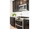 Contemporary kitchen with a stainless steel range, dark cabinets, and tiled backsplash at 14850 Munich Ave, Parker, CO 80134