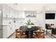 A modern kitchen features white cabinetry, a herringbone backsplash, and a black dining table at 14850 Munich Ave, Parker, CO 80134