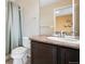 Bathroom showcasing a dark vanity with granite counters, toilet and shower behind the vanity at 19760 W 59Th Dr, Golden, CO 80403