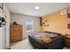 Bedroom featuring an orange accent wall, wooden dresser and a comfortable bed with unique decor at 19760 W 59Th Dr, Golden, CO 80403