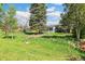 Lush backyard with mature trees and a well-maintained lawn, perfect for outdoor activities at 12046 W Green Mountain Dr, Lakewood, CO 80228