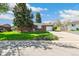 Charming brick ranch-style home with a well-maintained lawn and mature trees under a blue sky at 12046 W Green Mountain Dr, Lakewood, CO 80228