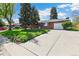 Well maintained lawn, mature trees, with a large driveway leading to a one car garage at 12046 W Green Mountain Dr, Lakewood, CO 80228