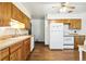 Clean kitchen with wood cabinets, white appliances, wood floors, and ample counter space at 12046 W Green Mountain Dr, Lakewood, CO 80228