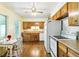 Sunlit kitchen with wood cabinets, white appliances, wood floors, and space for a small table at 12046 W Green Mountain Dr, Lakewood, CO 80228