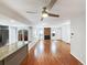 A spacious living room with wood floors, a ceiling fan, and a brick fireplace creating a cozy atmosphere at 9484 W 89Th Cir, Broomfield, CO 80021