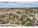 Expansive aerial view of a neighborhood with lush trees, winding roads, and scenic landscape at 8687 N Pinery Pkwy, Parker, CO 80134